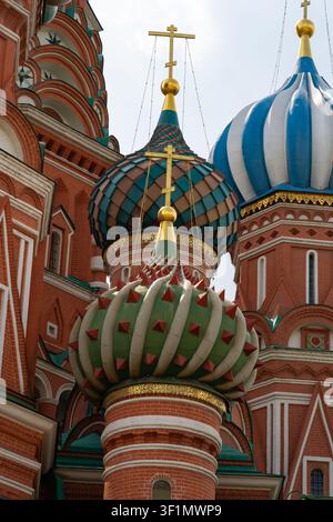 Close-up historical view of Saint Basils Cathedral onion domes with ornate patterns and golden crosses, red brick architecture, Moscow, Russia travel Stock Photo