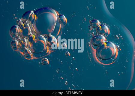 A captivating image of holographic bubbles floating against a dark blue background. The bubbles exhibit a vibrant spectrum of colors, highlighting the Stock Photo