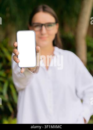 Woman showing blank smartphone screen outdoors for technology concept Stock Photo