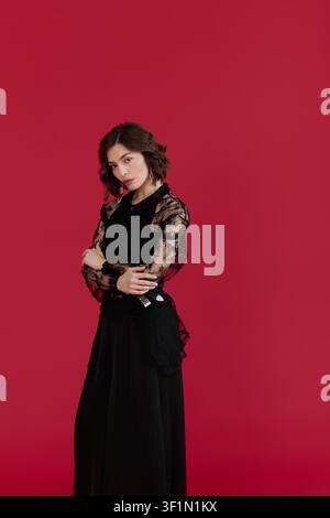 A stylish young woman showcases her fashion sense in lace and black attire while posing Stock Photo