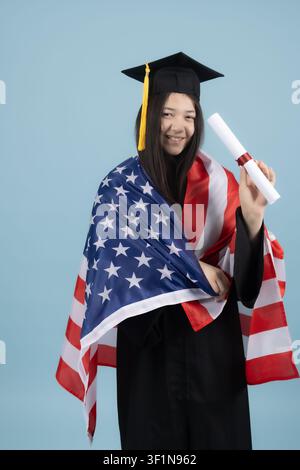 Proud female graduate holding college diploma and American flag Stock Photo