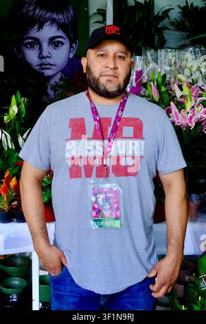 Mexico City, CDMX, Mexico – July 12, 2026: Male Florist Posing with Exhibitor Badge at Stall Stock Photo