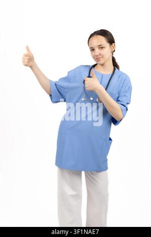 Cheerful female doctor standing in studio and showing thumbs up in the studio Stock Photo