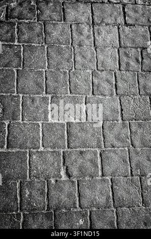 Abstract close-up of square stone paving blocks with textured surface. Stock Photo