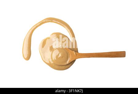 Tahini in wood bowl isolated, sesame seeds paste, smeared tahina sauce, eastern dip, traditional oriental cuisine ingredient, ground sesame spoon on w Stock Photo