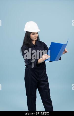 Female architect checking documents on a clipboard in the studio Stock Photo