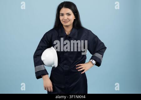Professional female mechanic standing confidently in the studio Stock Photo