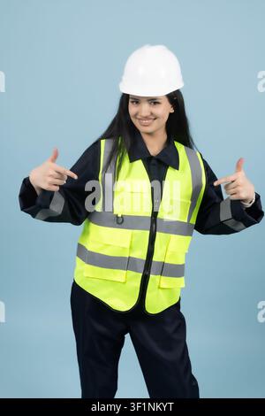 Confident female builder standing with hands on hips in the studio Stock Photo