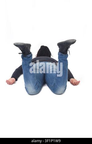 woman lying face down on the floor with her legs raised Stock Photo