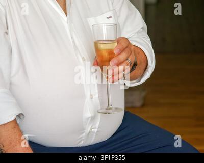 Man holding a glass of sparkling wine during a wedding reception celebration Stock Photo