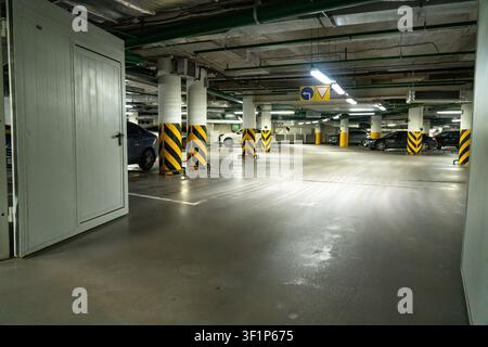 A Spacious and Well-Lit Underground Parking Garage with Clear Signage and Safety Markings Stock Photo