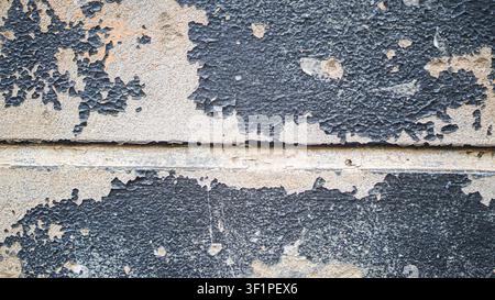 Peeling blue paint on a textured concrete wall Stock Photo