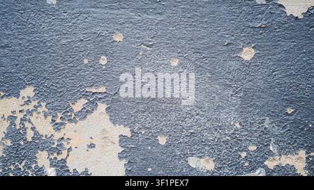 Peeling blue paint on a textured concrete wall Stock Photo