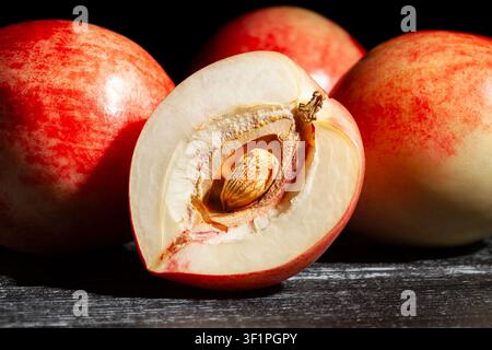 sliced white nectarine on black wood background Stock Photo