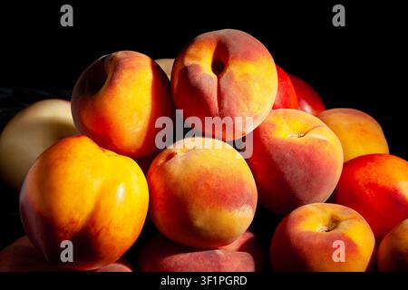 mixed peaches heap on black background Stock Photo