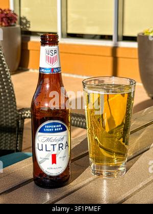 Page, Arizona, USA - 30 June 2026: Bottle of Michelob Ultra light lager beer and a full glass on a table on the terrace of a hotel. Stock Photo