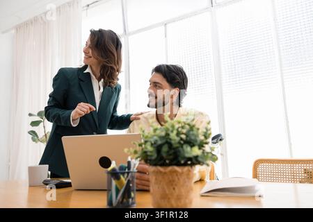 Business colleagues collaborating at office workplace with laptop Stock Photo