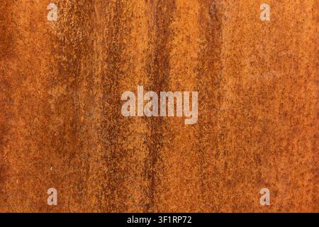 Rusted metal sheet texture background, close up of weathered orange rust spots and corrosion runs on metallic surface, detailed full frame oxidized Stock Photo