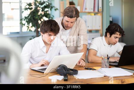 Team of managers work together in a modern office with documents and on Internet Stock Photo
