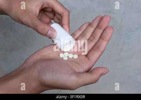 Medicine Bottle Pouring Pills into Open Hand Stock Photo