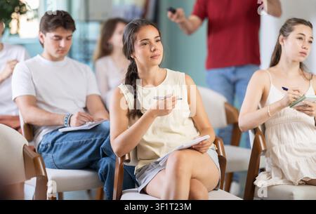 Group of people listening to a lecture and taking notes Stock Photo