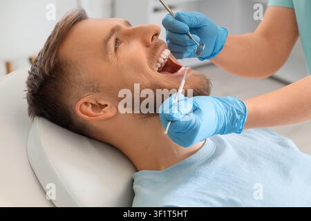 Young man visiting dentist on couch in clinic, closeup Stock Photo
