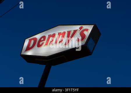 An Illuminated Denny’s pole sign with dark blue sky in the night is shown. Dallas, Texas, USA. Stock Photo