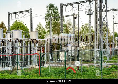 High voltage electrical substation with power transformers under modern security camera surveillance Stock Photo