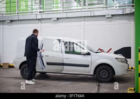 Adult Man Opening Delivery Van in Individual Storage Facility Stock Photo