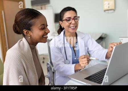 Happy doctor woman showing medical screening result to African patient Stock Photo