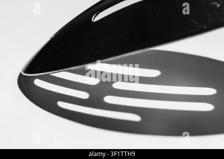Slotted spatula head casting fan shaped shadow in black and white Stock Photo