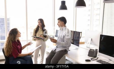 Diverse businesspeople collaborating on strategy at corporate office Stock Photo