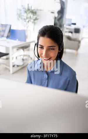 Smiling support agent assisting clients online Stock Photo