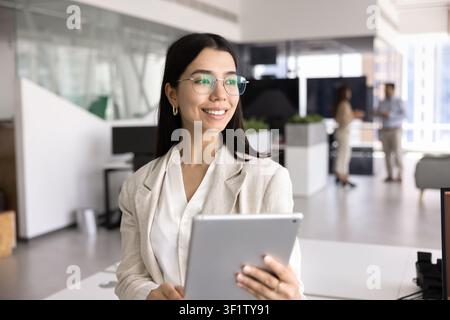 Attractive woman standing in coworking office with modern digital tablet Stock Photo