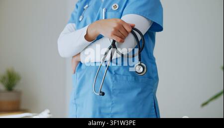 Doctor, hands or arms crossed in clinic with stethoscope, cardiology specialist or medical expertise. Career, person or heart health physician in Stock Photo