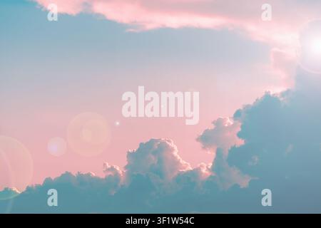 Gentle pastel pink and blue sky creating a serene background, featuring soft fluffy clouds, and bright sun flares adding an ethereal glow to the tranq Stock Photo
