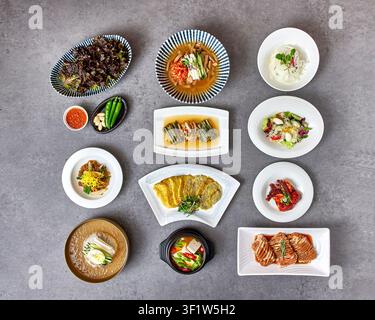 Traditional Korean full course meal hanjeongsik with multiple dishes including grilled meat, seasoned vegetables, rice, soup and various banchan side Stock Photo
