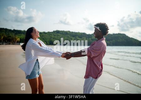 Carefree couple enjoying a tropical beach vacation, laughing making unforgettable memories together Stock Photo