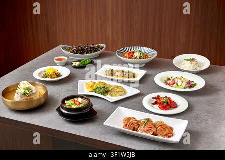 Traditional Korean full course meal hanjeongsik with multiple dishes including grilled meat, seasoned vegetables, rice, soup and various banchan side Stock Photo