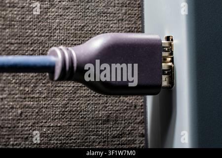 DisplayPort cable plugged into device port close up. Macro view black digital interface cable connected to electronic device socket. Concept of data t Stock Photo