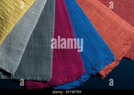 Colorful linen fabric swatches. Fan selection of textured linen fabric samples in various vibrant colors showing material quality for fashion, textile Stock Photo