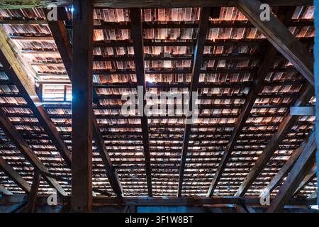Old rustic attic with sunlight coming through red tile roof Stock Photo