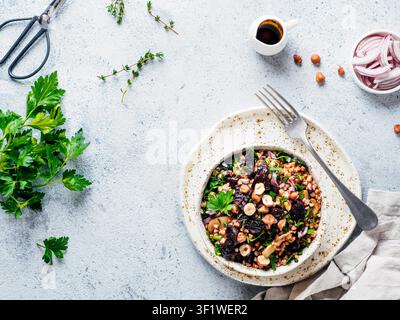 Vegetarian diet salad with beet, buckwheat grains, mushrooms, red onion and fresh herbs in bowl. Warm buckwheat and beetroot salad on gray concrete background. Top view. Copy space Stock Photo