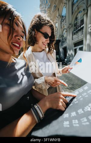 Two businesswomen collaborating on outdoor presentation with charts and a tablet in city street Stock Photo