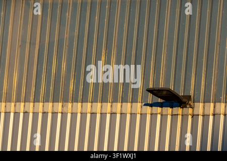 Modern LED Floodlight on Industrial Corrugated Metal Wall Stock Photo