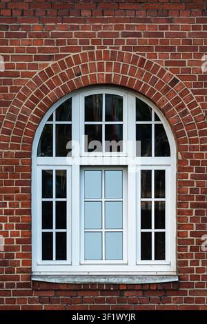 Traditional White Arched Window on Red Brick Wall Facade Stock Photo
