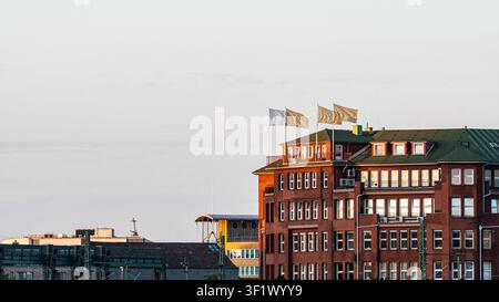 Classic Red Brick Corporate Building with Flags at Sunset Stock Photo