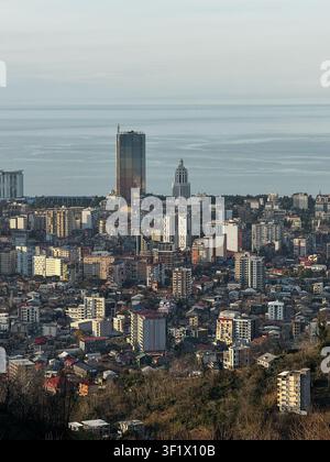Panoramic view of Batumi city skyline with tall buildings and sea horizon under warm evening light Stock Photo