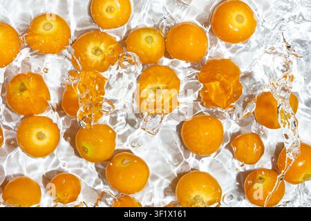 Fresh physalis berries in water splash for refreshing food concept Stock Photo