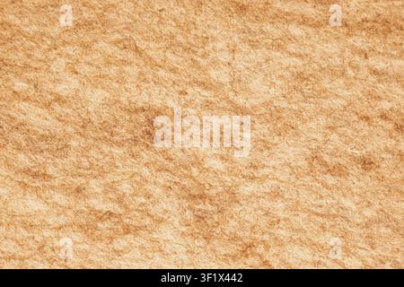 Horizontal close up of a rustic warm beige brown felt fabric material showing detailed dense organic pressed wool fibers on a cozy textured backdrop s Stock Photo
